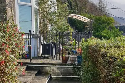 a wrought iron fence in front of a house with potted plants at Seaview Apartment Sleeps 2 -Patio -WiFi -Tv in Barmouth