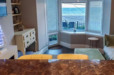 a living room with a table and chairs and a window at Seaview Apartment Sleeps 2 -Patio -WiFi -Tv in Barmouth