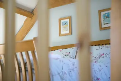 a bedroom with a bed with blue sheets and pictures on the wall at Finest Retreats - 1 Bed Llangollen Cottage - Sleeps 2 in Llangollen