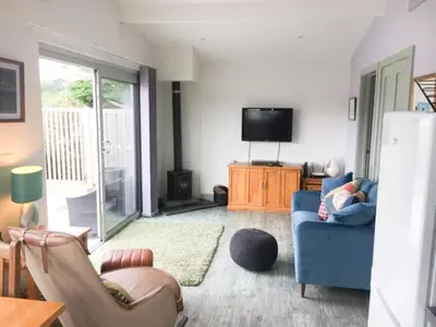 a living room with a blue couch and a tv at Abergafren Lodge in Porthmadog