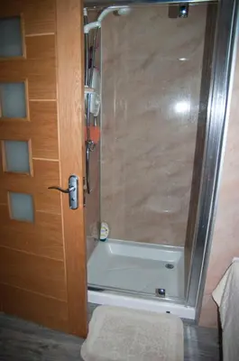 a shower with a glass door in a bathroom at Abergafren Lodge in Porthmadog