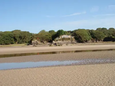 a house sitting on the shore of a beach at Abergafren Lodge in Porthmadog