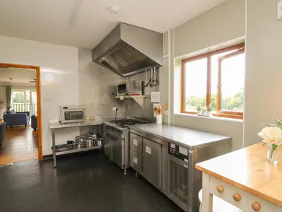 a kitchen with stainless steel appliances and a counter at Llety Ceiro in Bow Street