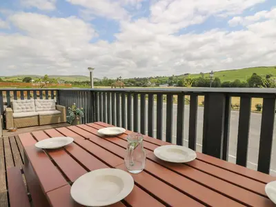 a wooden table with plates on top of a deck at Llety Ceiro in Bow Street