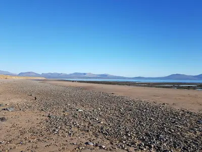 a beach with rocks and the ocean in the background at Bennar Isa Cottages Dyffryn Ardudwy in Barmouth