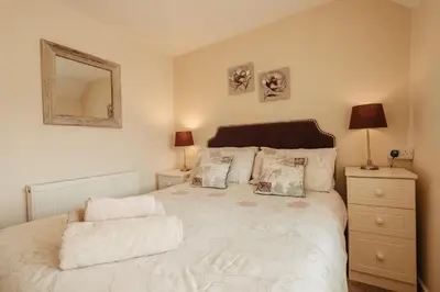 a bedroom with a bed with a mirror and a dresser at Bennar Isa Cottages Dyffryn Ardudwy in Barmouth