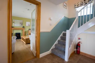 a staircase in a home with a blue wall at Bennar Isa Cottages Dyffryn Ardudwy in Barmouth