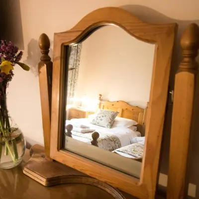 a mirror on a table next to a bed at Plas Dolau Country Estate in Aberystwyth
