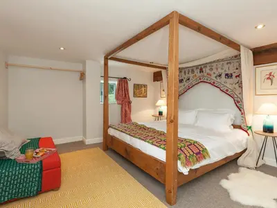 a bedroom with a canopy bed and a couch at Rhydleos Mill in Llansilin
