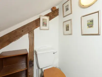 a bathroom with a toilet and framed pictures on the wall at Rhydleos Mill in Llansilin
