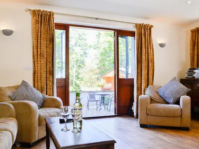 a living room with two couches and a table with wine glasses at Ty Cregyn - Uk11957 in New Quay