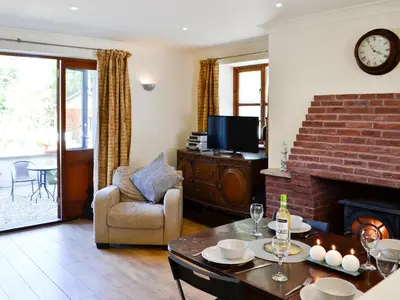 a living room with a table and a fireplace at Ty Cregyn - Uk11957 in New Quay