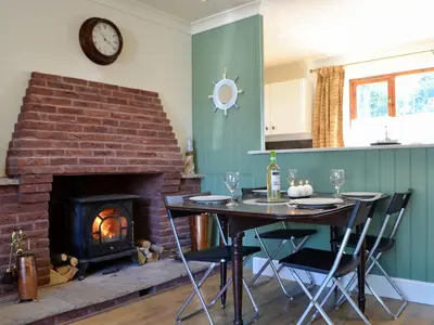 a dining room with a table and a fireplace at Ty Cregyn - Uk11957 in New Quay