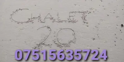 a sign written in the sand on the beach at Springside Chalet20 in Tywyn