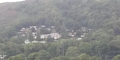 a group of houses on a hill with trees at Springside Chalet20 in Tywyn