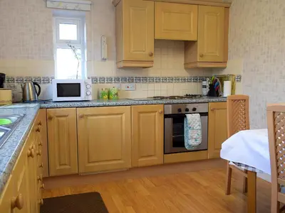 a kitchen with wooden cabinets and a stove top oven at Kinverley in Evenjobb