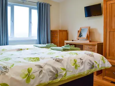 a bedroom with a bed and a television and a window at Sweet Meadow Lodge in Llandrindod Wells