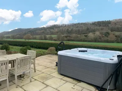 a hot tub on a patio with a table and chairs at Pendennis at Eaton Manor in Church Stretton