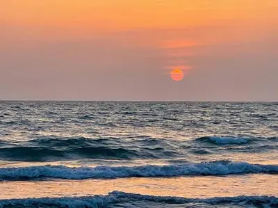 a sunset over the ocean with the sun in the sky at Chalet Kiss of the Sea in Aberystwyth