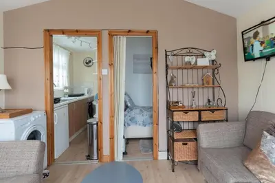 a living room with a couch and a kitchen at Chalet Kiss of the Sea in Aberystwyth