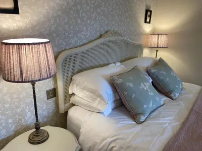 a bedroom with a bed with pillows and a lamp at Cwmbach Lodge luxury B&B in Glasbury