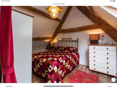 a bedroom with a bed and a dresser in a attic at Ty Fferm Hen, Ancient Farmhouse, Coity Bach in Talybont