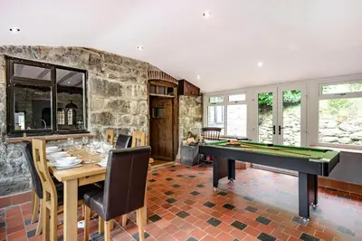 a dining room with a table and a pool table at Groes Heol in Machynlleth