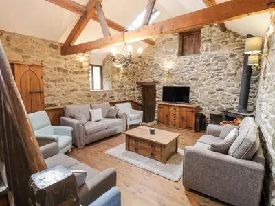 a living room with furniture and a stone wall at Groes Heol in Machynlleth