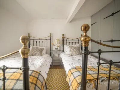 a bedroom with two beds and a night stand at Bwthyn Dyfi in Machynlleth
