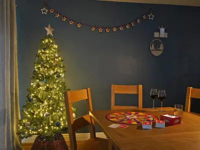 a christmas tree in a dining room with a table at Bryn Derw in Barmouth