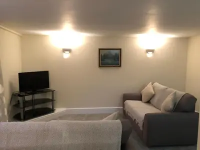 a living room with a couch and a tv at 9 Bromleys Court in Church Stretton