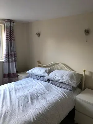 a bed with white sheets and pillows in a bedroom at 9 Bromleys Court in Church Stretton