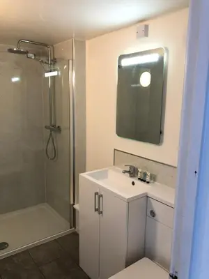 a bathroom with a sink and a shower with a mirror at 9 Bromleys Court in Church Stretton