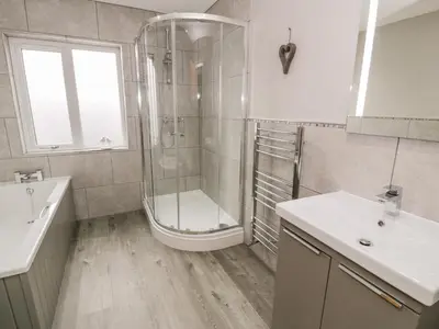 a bathroom with a shower and a sink and a tub at Cartref in Trawsfynydd