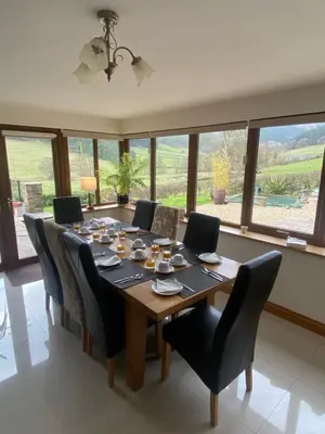 a dining room with a wooden table and chairs at Laurel Bank in Abbey-Cwmhir