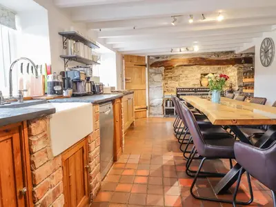 a kitchen with a table and chairs and a counter at Cefn Nannau in Corwen