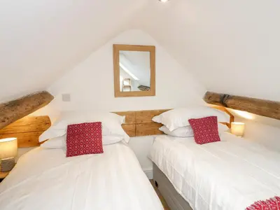 two beds in a attic room with a mirror at Cefn Nannau in Corwen
