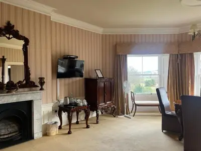 a living room with a fireplace and a television at Netley Hall in Shrewsbury
