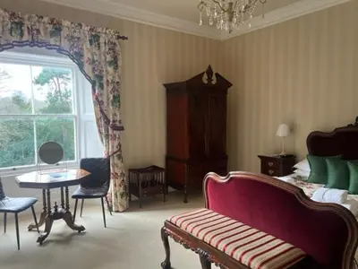 a bedroom with a couch and a bed and a window at Netley Hall in Shrewsbury