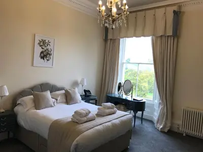 a bedroom with a bed with towels on it at Netley Hall in Shrewsbury