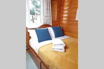 a bed in a log cabin with a window at Rustic Log cabin in Snowdonia By Seren Short Stays in Trawsfynydd