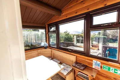 a room with three windows in a house at Log Cabin nr Coed y brenin By Seren Short Stays in Trawsfynydd