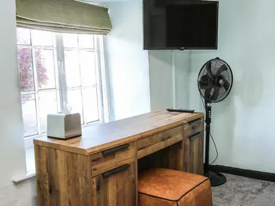 a room with a desk with a fan and a window at The Boars Head Pub in Bishops Castle