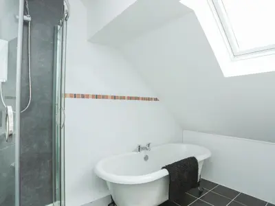 a white bathroom with a tub and a shower at Red Ridge in Harlech