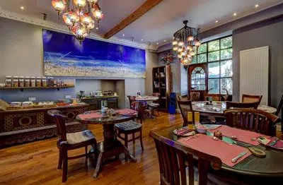 a restaurant with tables and chairs in a room at Borthwnog Hall in Dolgellau