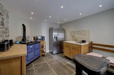 a kitchen with blue cabinets and a stove top oven at Borthwnog Hall in Dolgellau