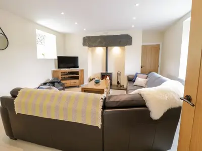 a living room with a brown leather couch at Bryn Mawndy in Corwen