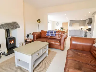 a living room with a leather couch and a table at Bryn Mawndy in Corwen