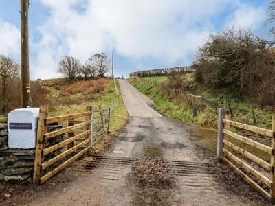 a dirt road with a fence on the side at Bryn Mawndy in Corwen