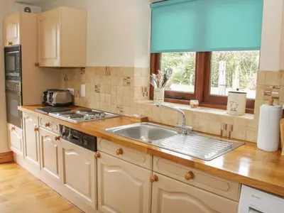 a kitchen with a sink and a window at Minton Lane Cottage in Church Stretton